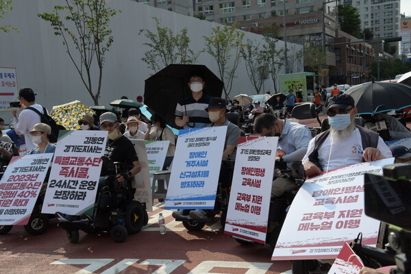 4일 오후 5시 경 경기도청 후문 앞에서 열린 '경기도 장애인 권리 예산 보장 촉구 결의대회' 참가자들이 피켓을 들고 있다. (서다은 기자)